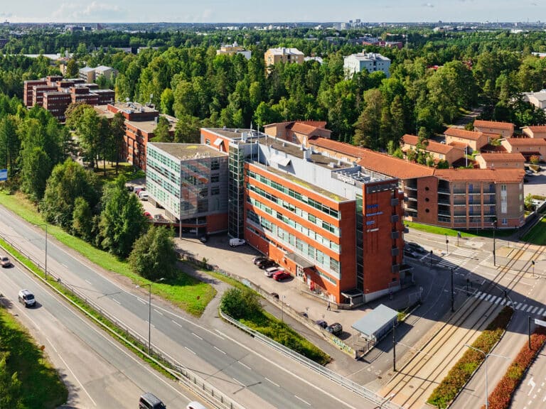 Ilmasta kuvattu X Haaga. Vierestä kulkee pikaratikan raiteet sekä pyörätie. Taustalla puita ja etualalla Hämeenlinnanväylä.